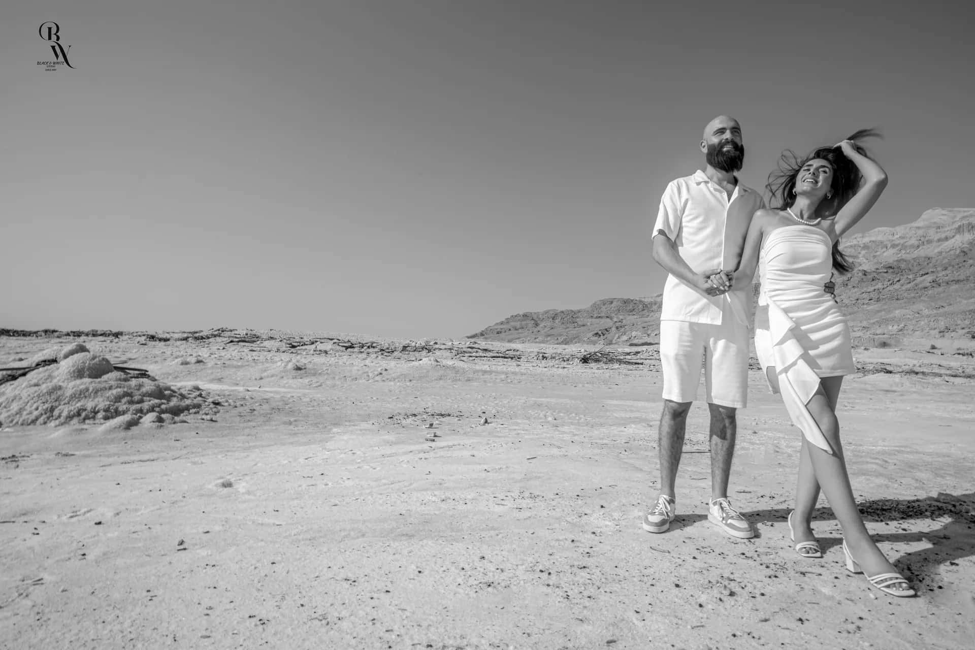 A couple dancing on the salt shore, in black and white