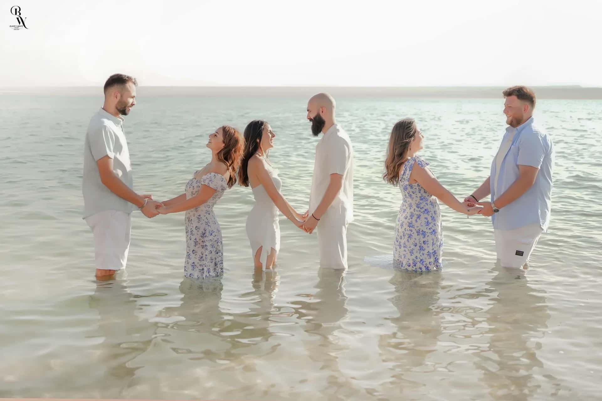 Three couples holding hands in the Dead Sea