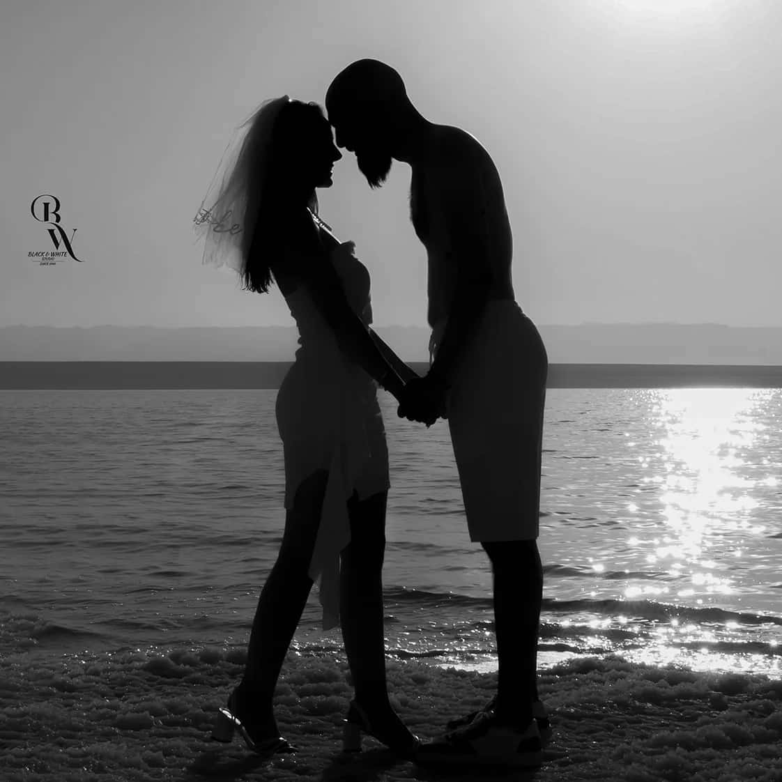 A couple in silhouette at the water's edge