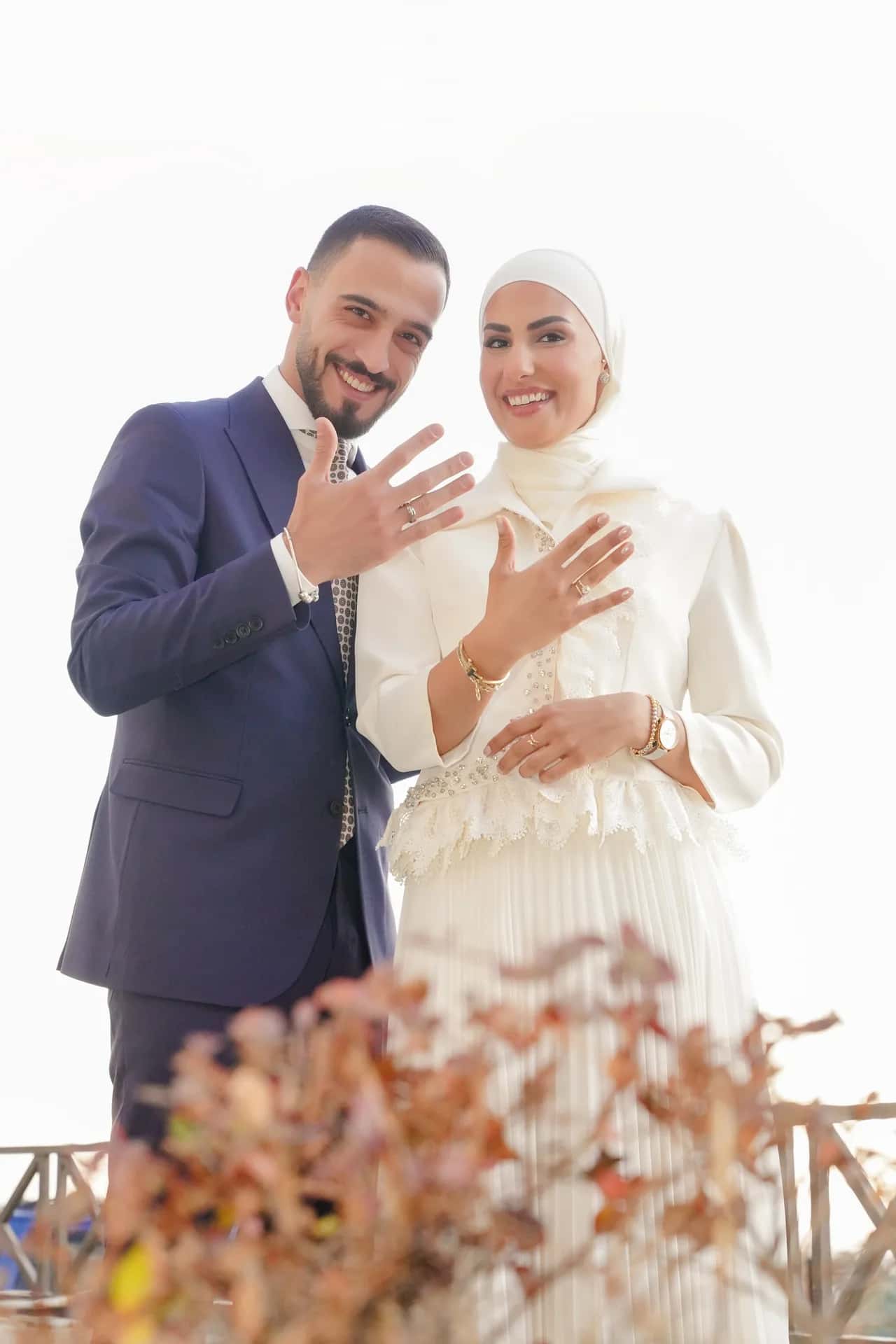 A couple showing their rings, smiling