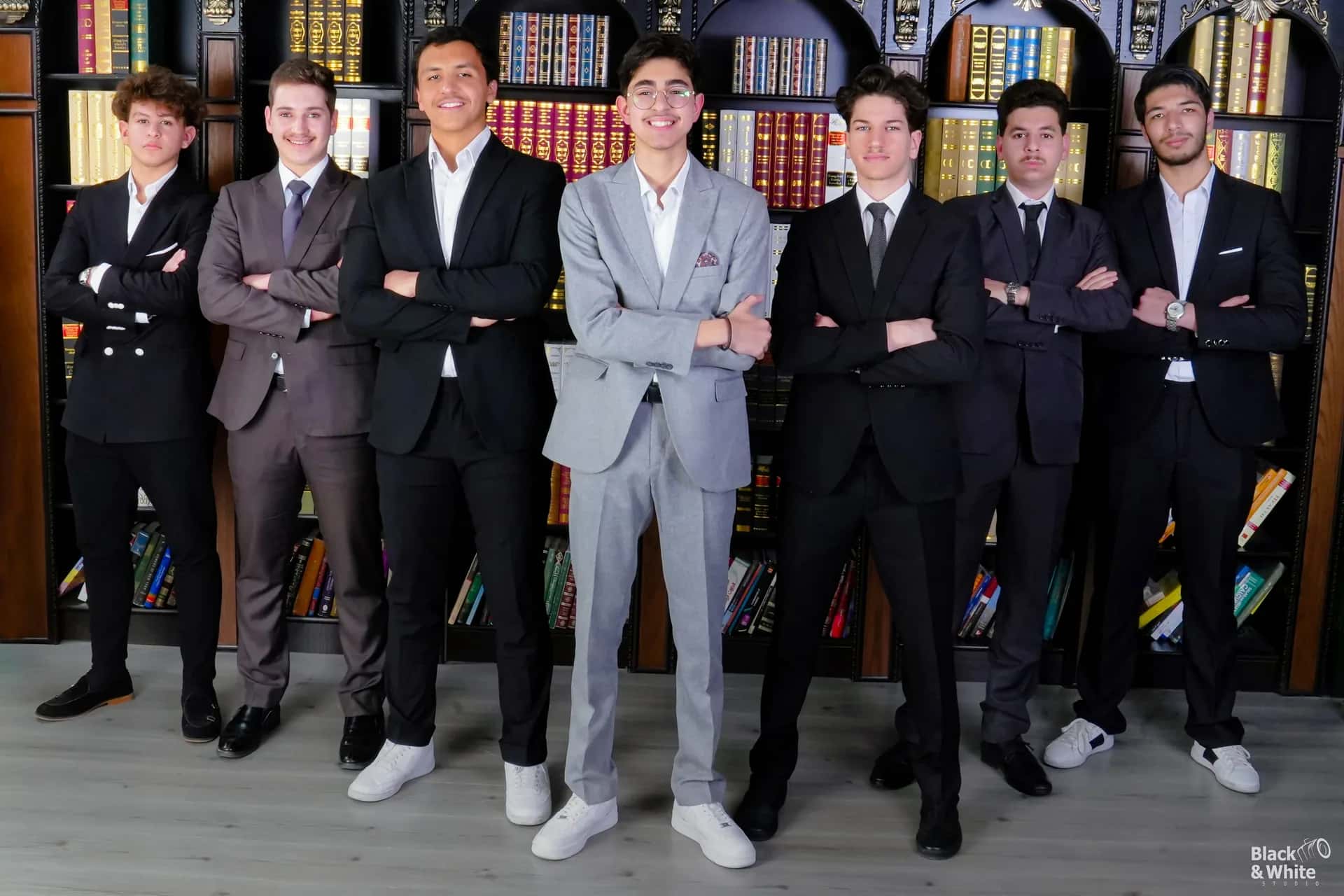 A group of graduates in suits in the studio library