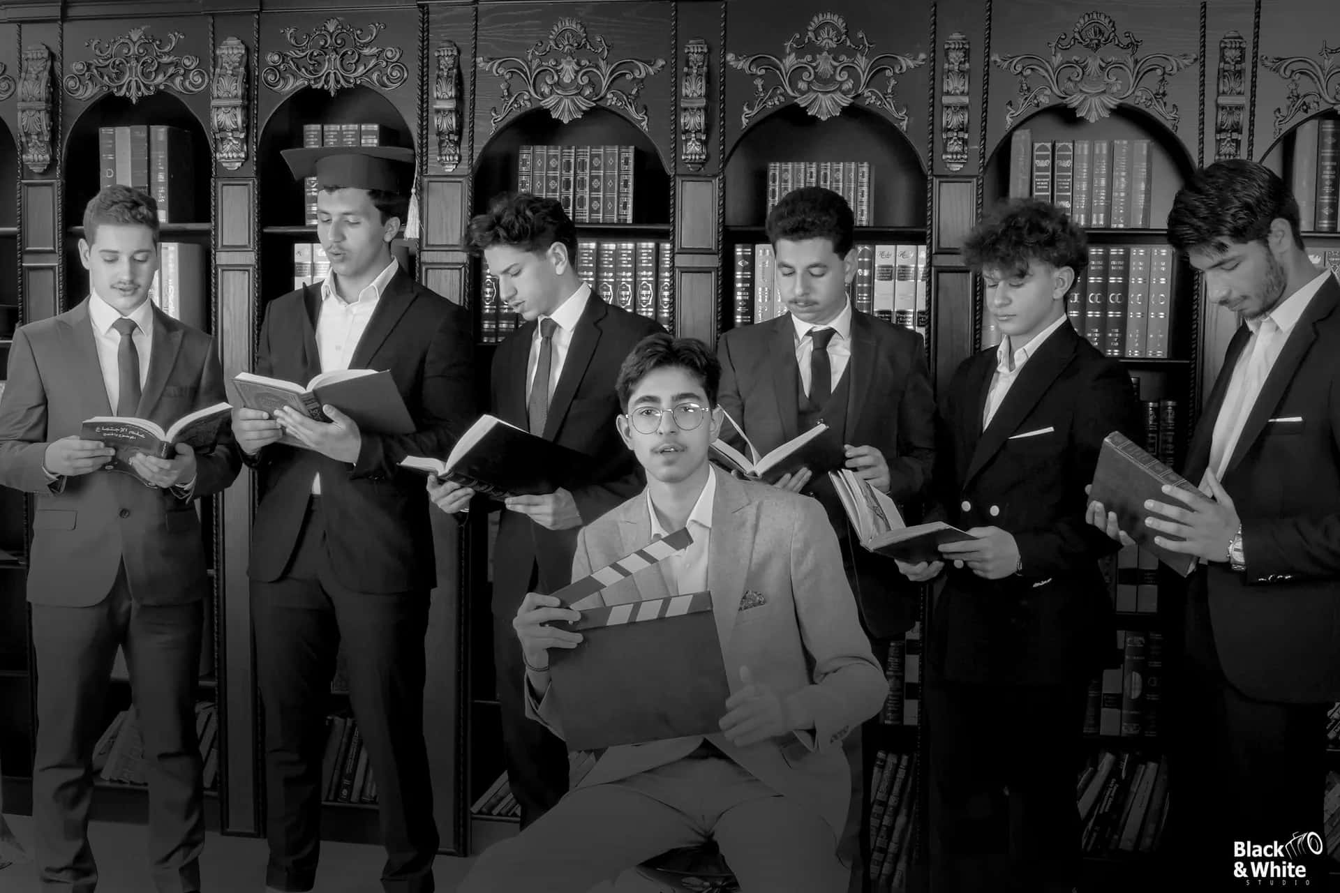 Graduates reading books in the library set, in black and white
