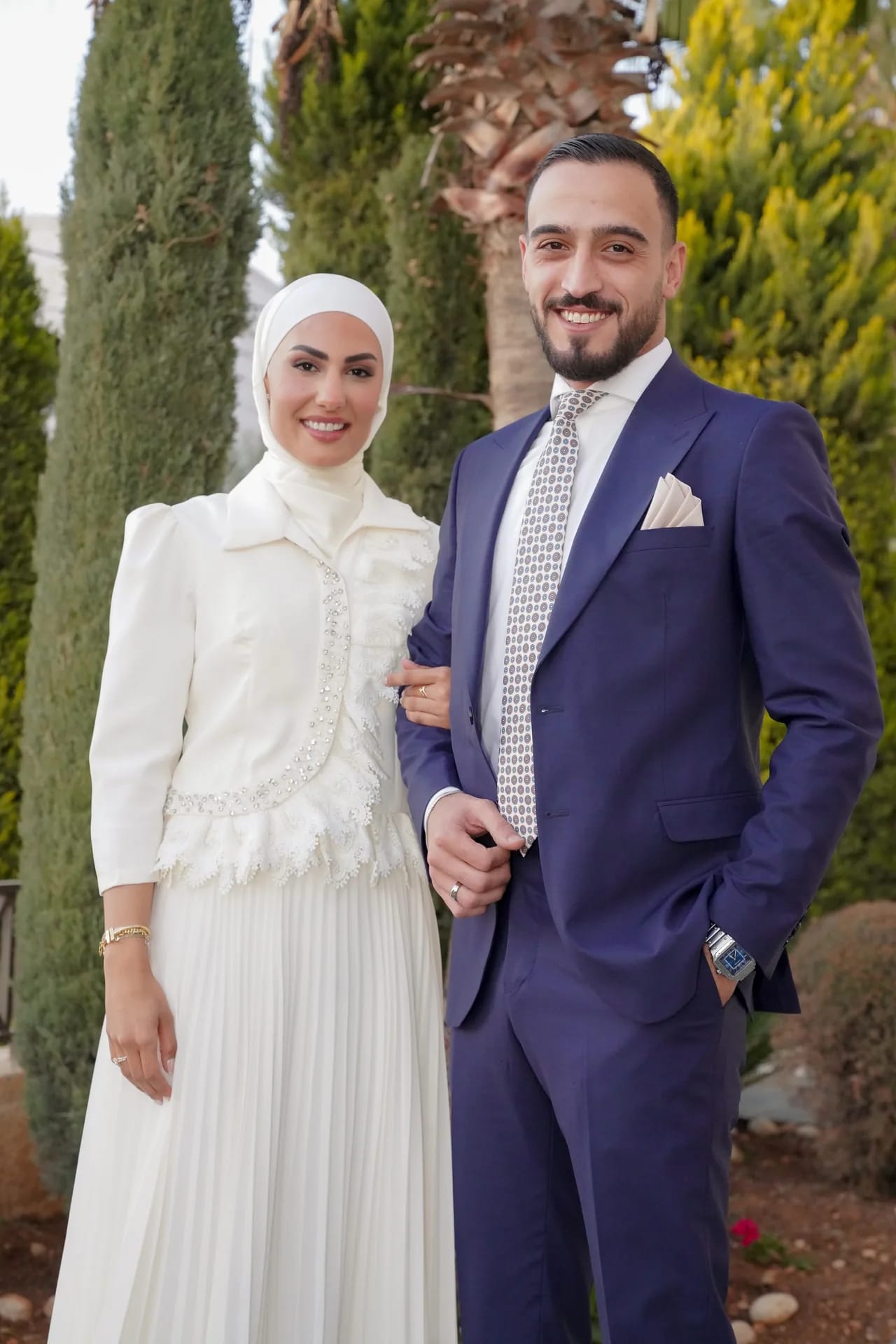 A couple standing together among cypress trees