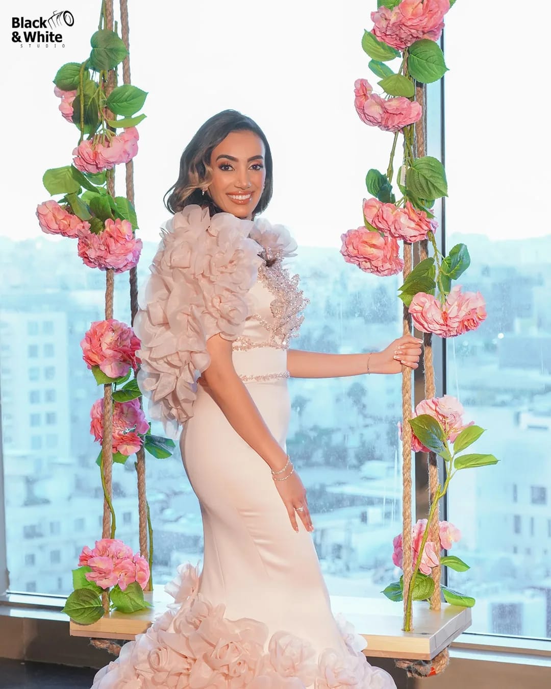 A bride on a flower swing above the city