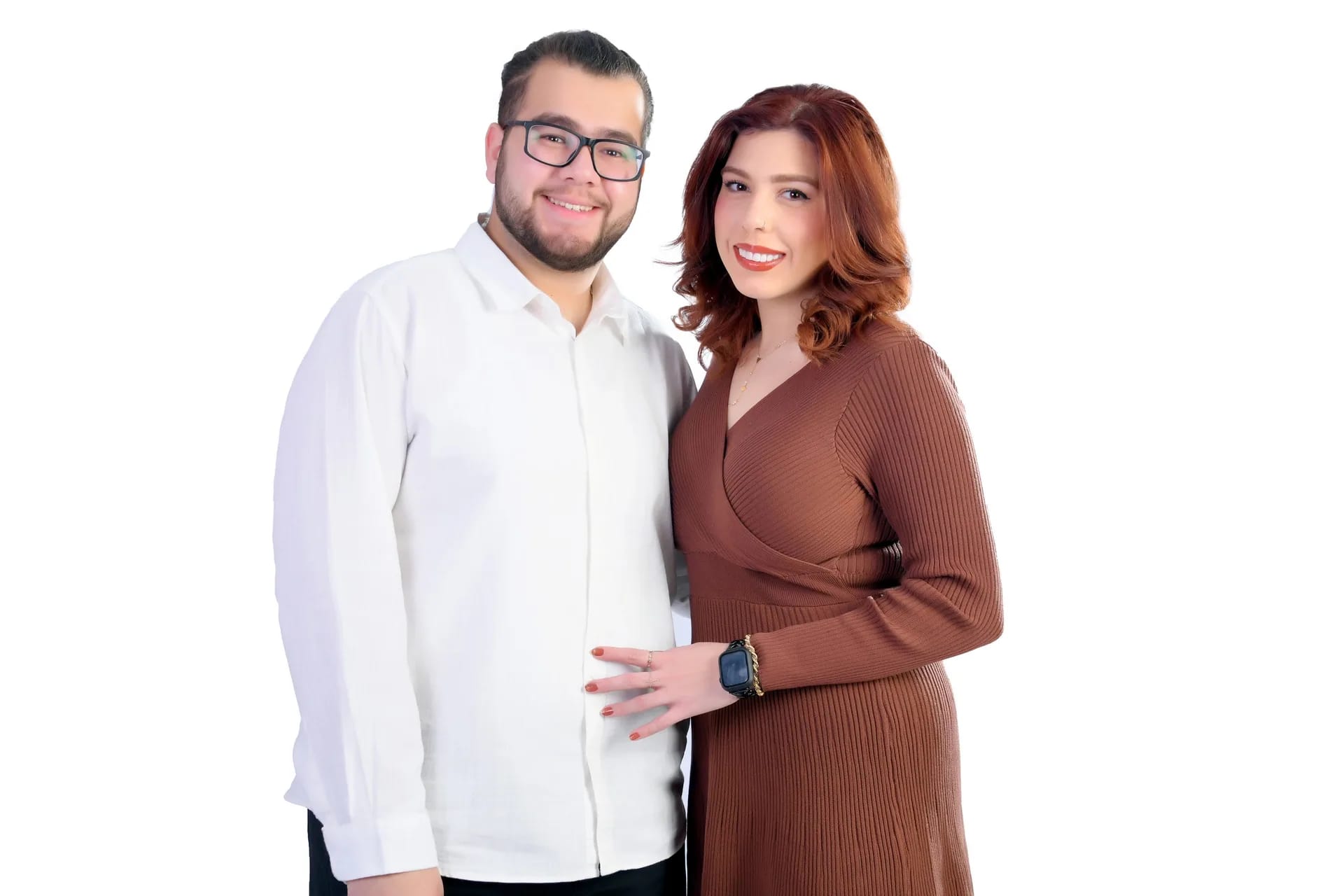 A couple standing together on a white studio backdrop