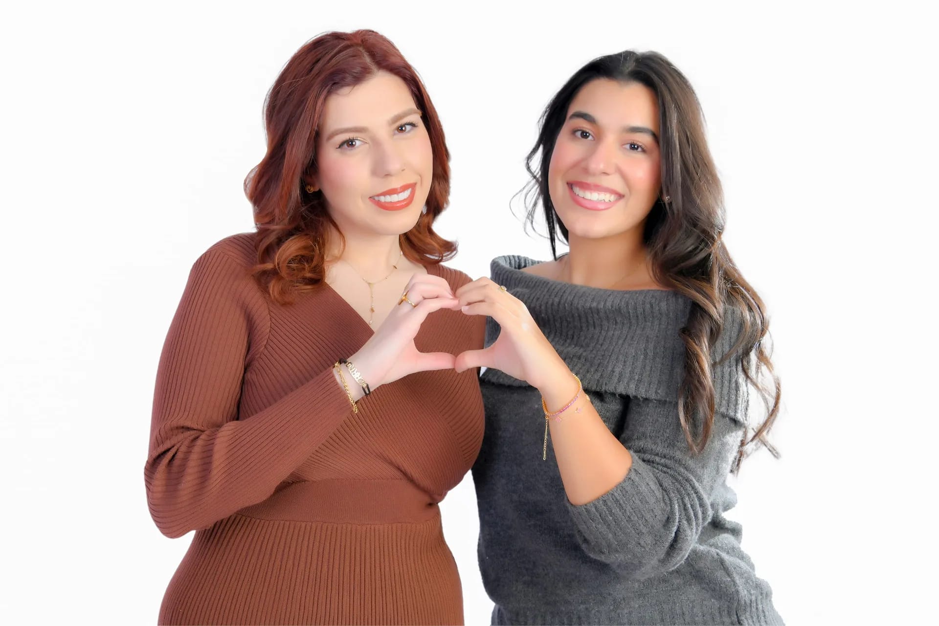 Two sisters making a heart with their hands