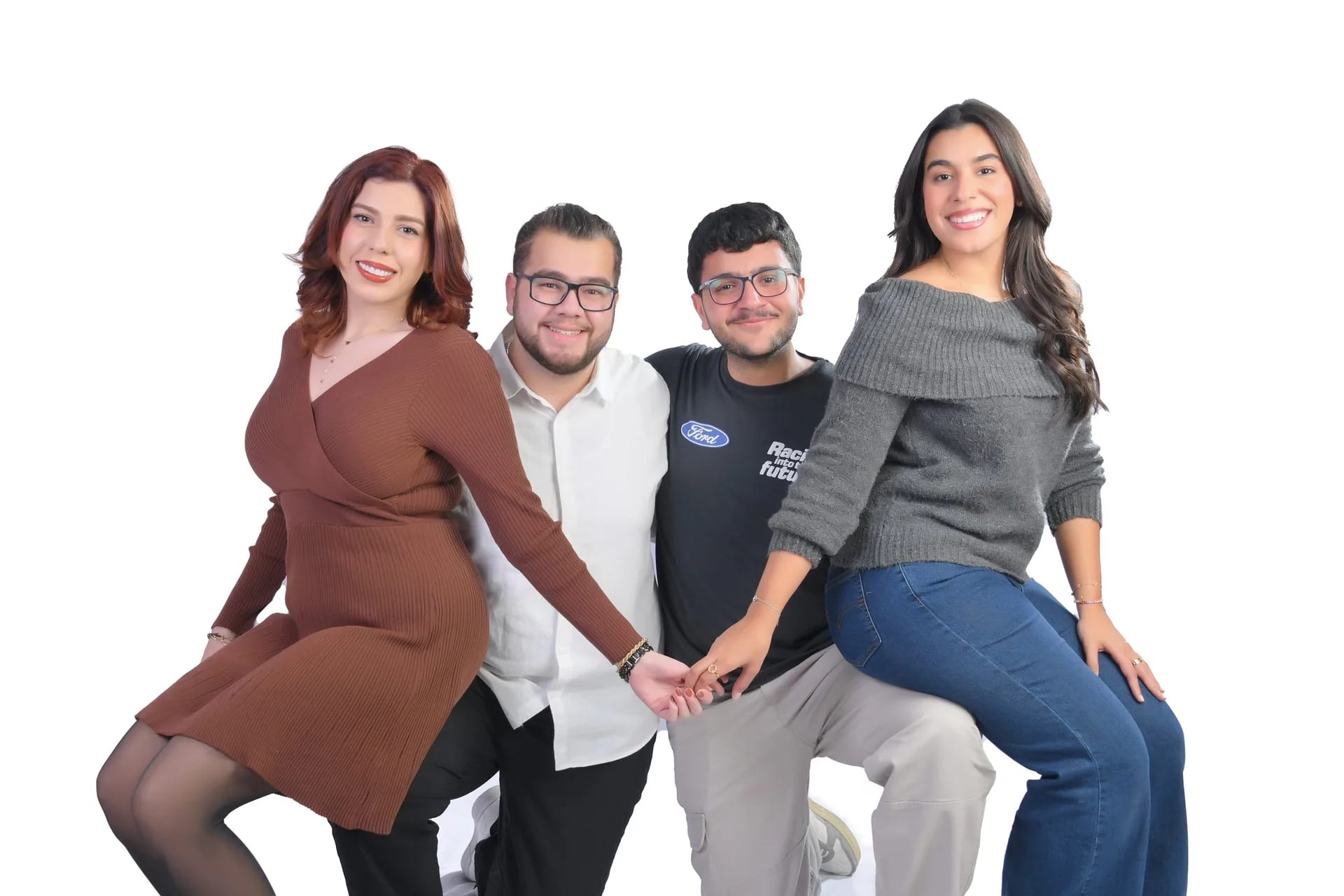 Four siblings sitting together on a white backdrop