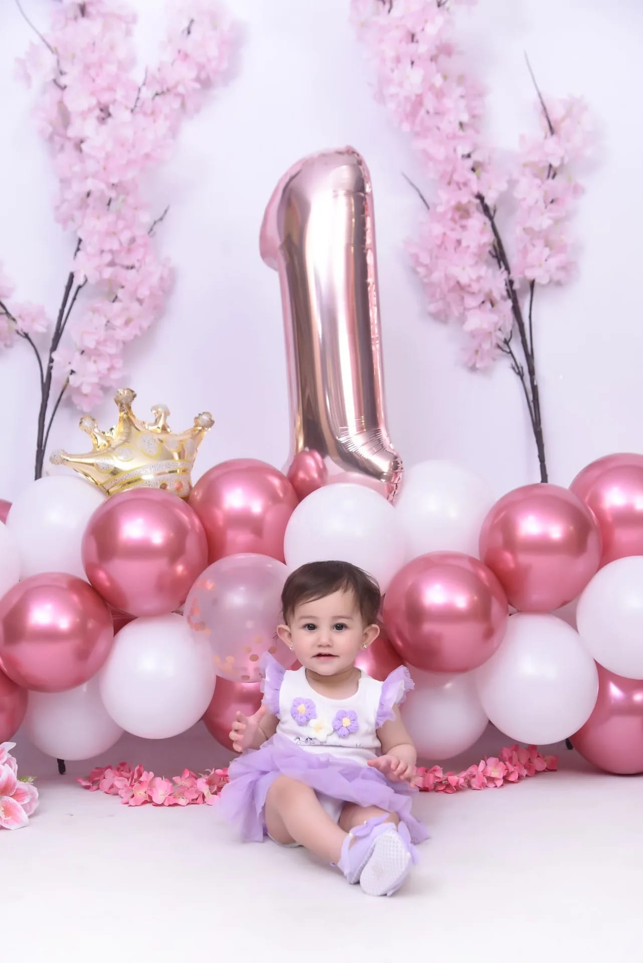 A one-year-old among pink balloons for her first birthday
