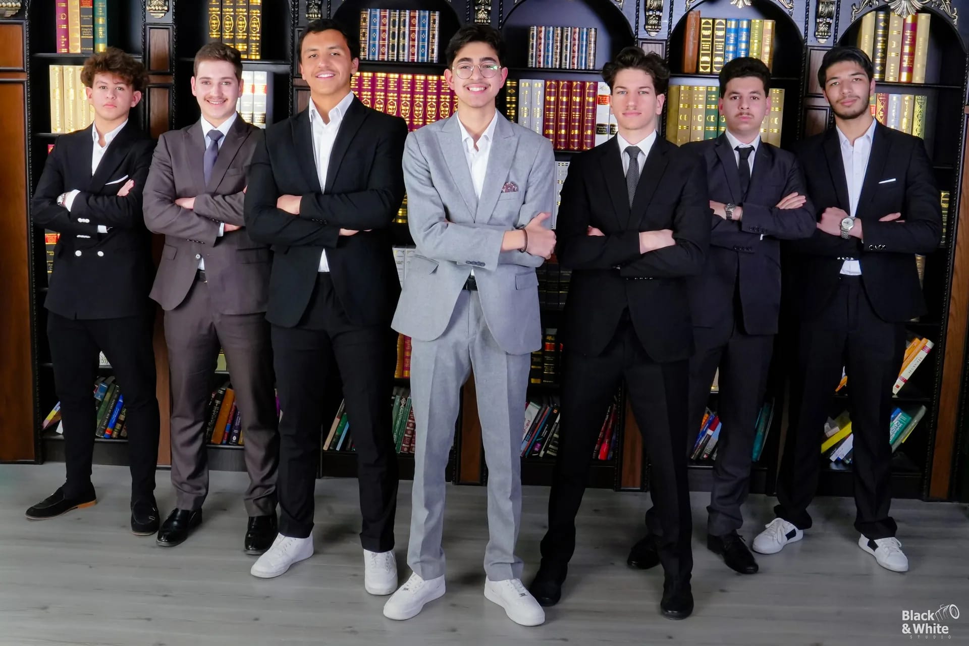 A group of graduates in suits in the studio library