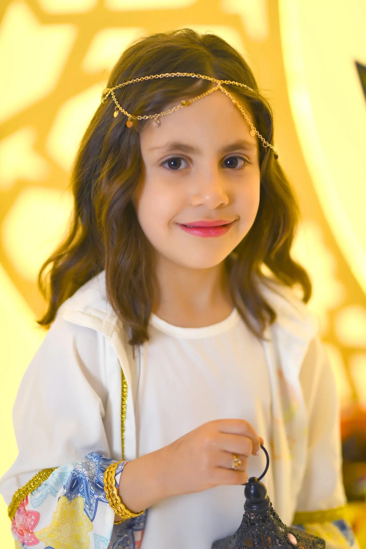A girl in white smiling in golden Ramadan light