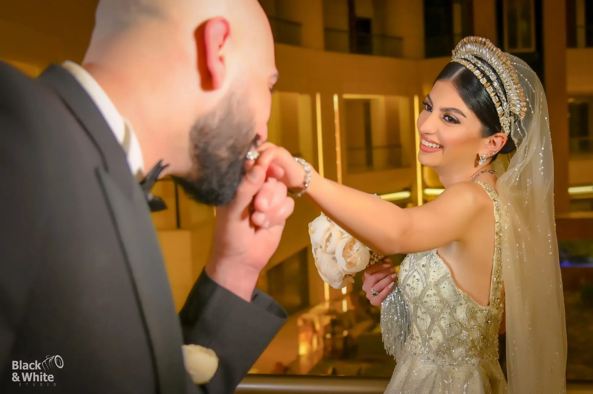 A groom kissing his bride's hand