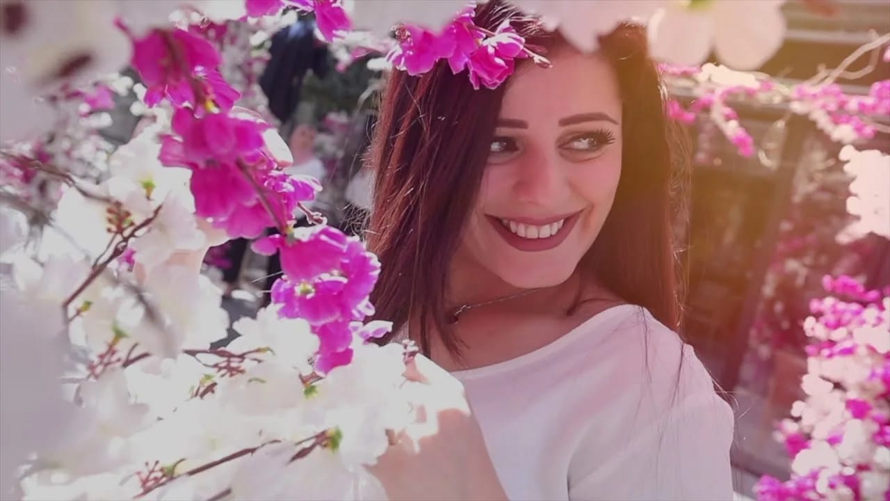 A student smiling under bougainvillea, Petra University