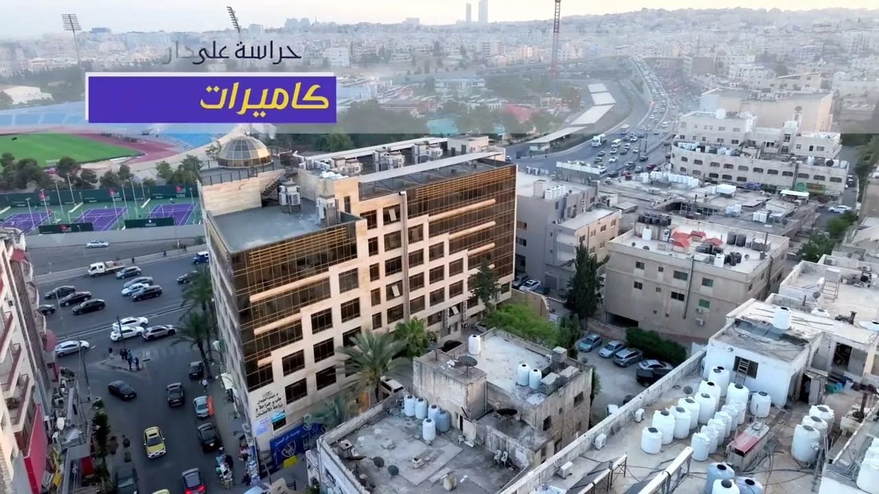 An aerial view over a commercial complex and the city of Amman