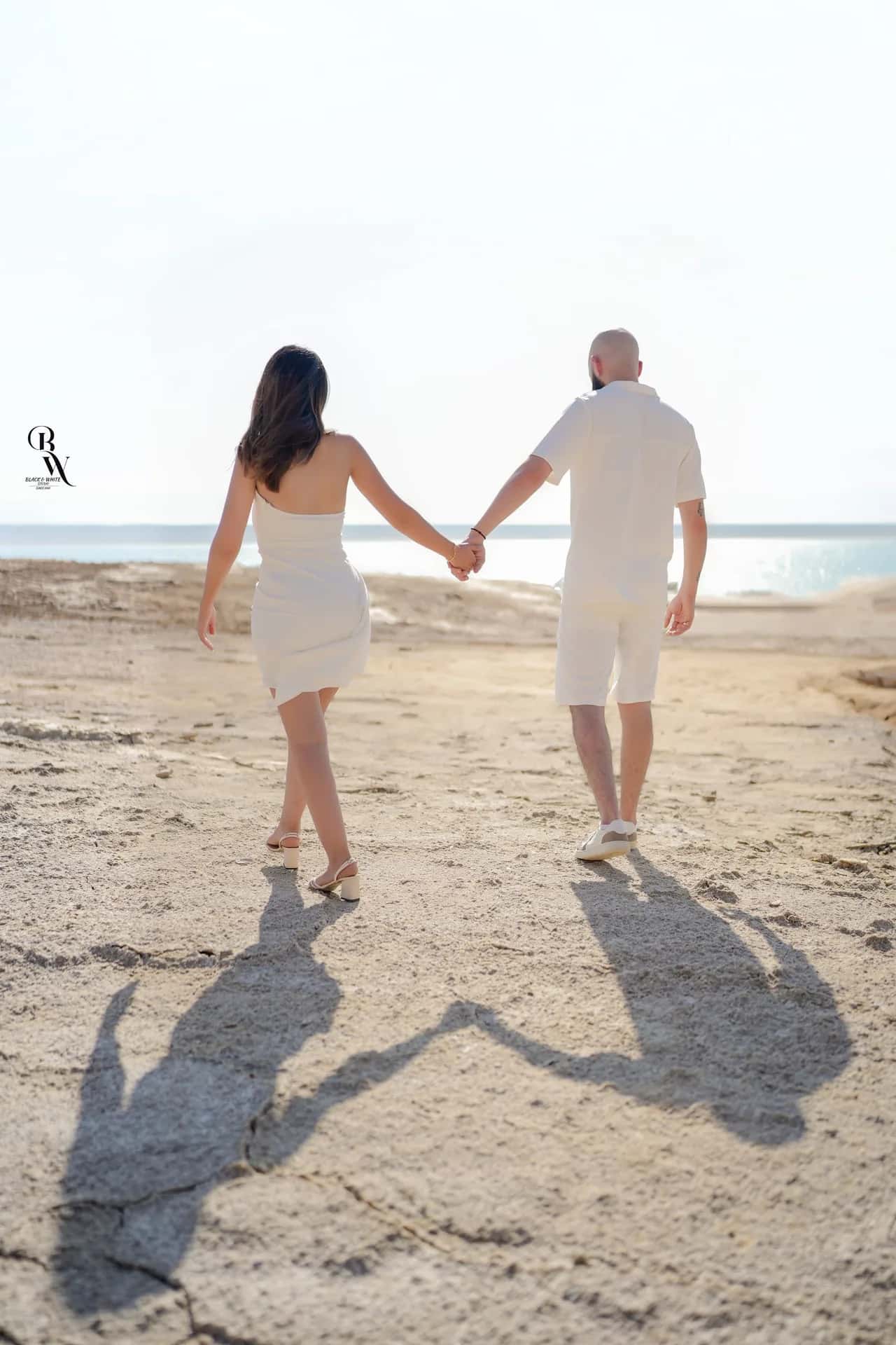 A couple walking hand in hand across the salt flats