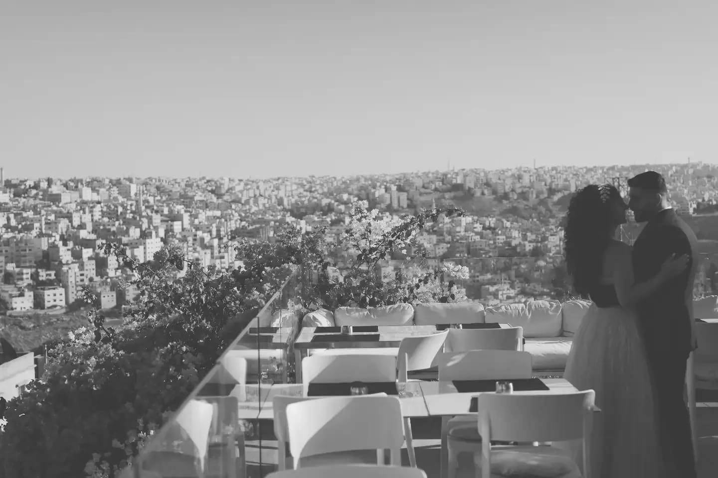 A couple about to kiss on a terrace above the city of Amman, in black and white