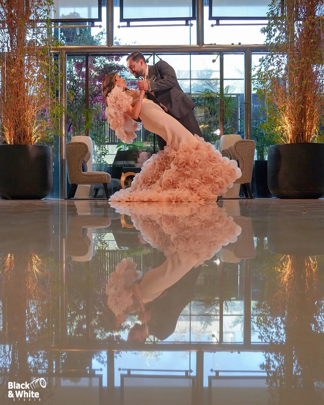 A couple dancing on a glass-walled terrace