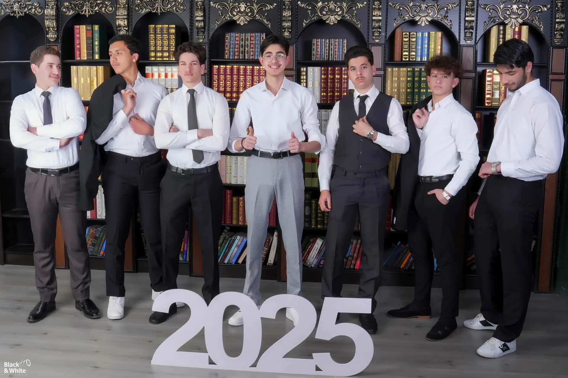 A class of 2025 standing behind the year in large letters