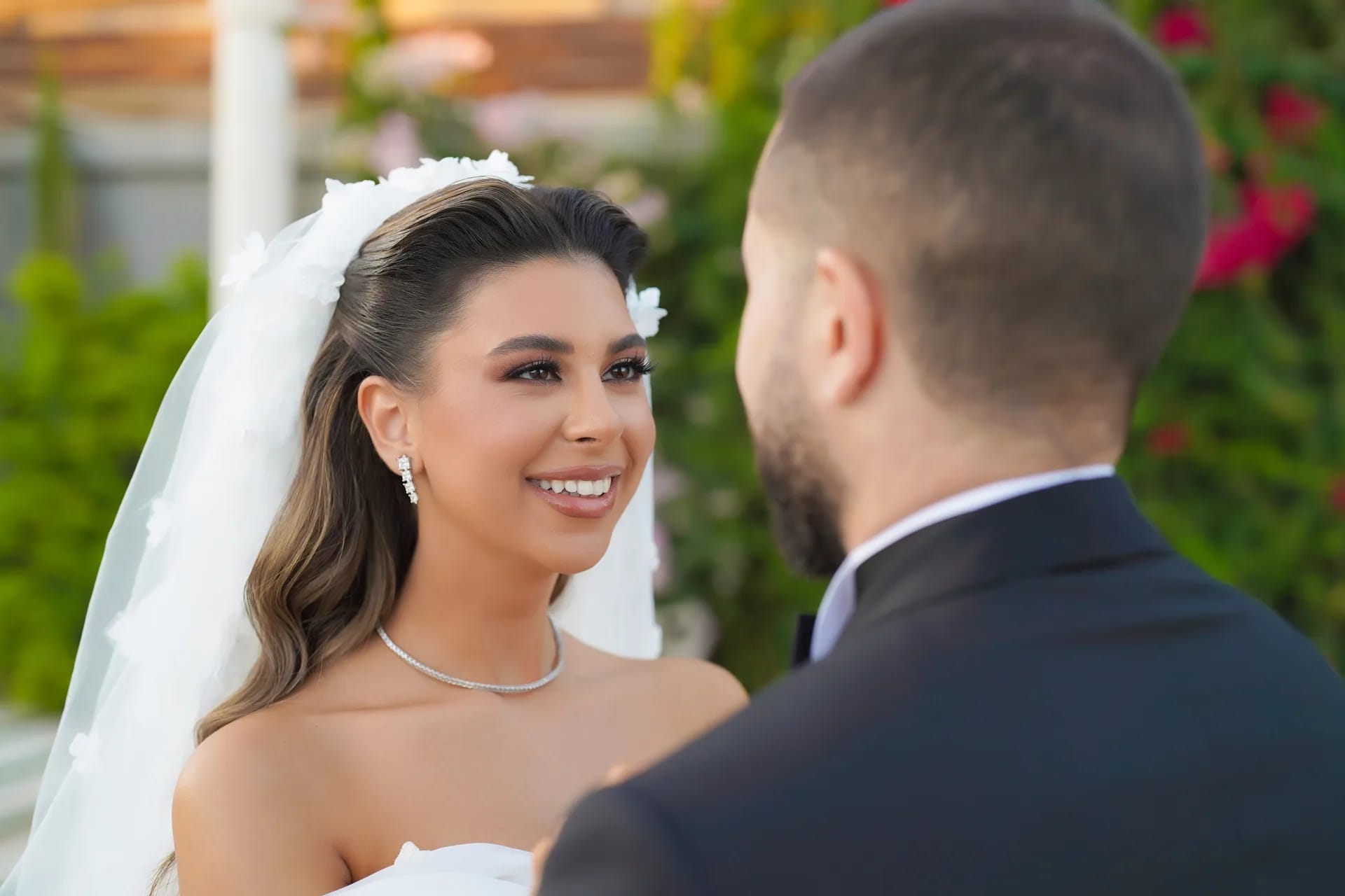 A bride laughing as she looks at her groom