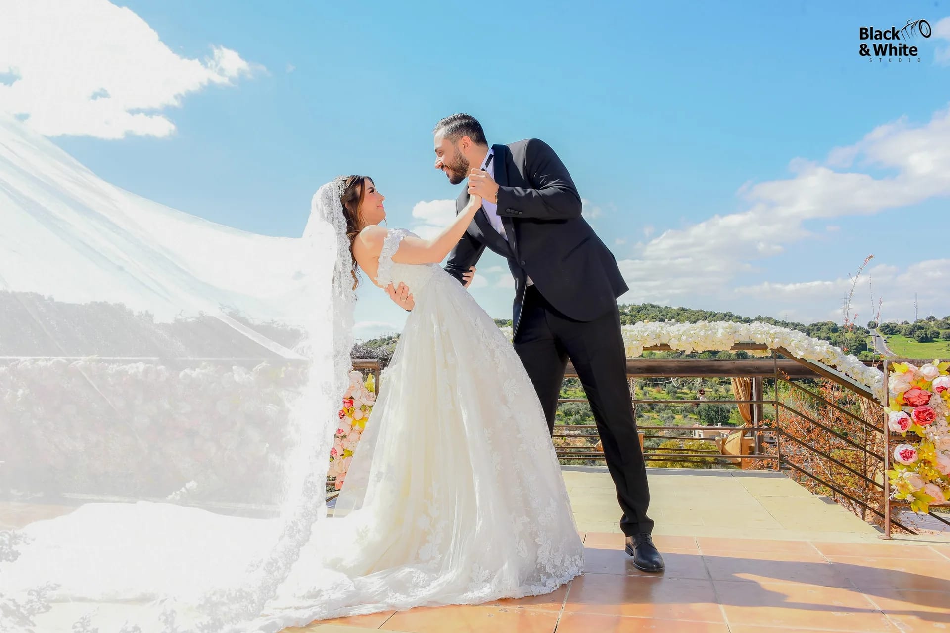 A groom leaning toward his bride on an open terrace